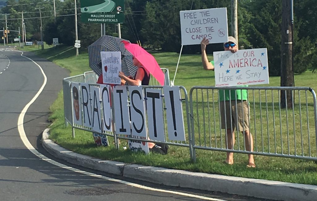 Protesters, including members of NJ 11th for Change and CD 7 for Change, marked the arrival of President Donald J. Trump to Bedminster with signs accusing Trump of racism.