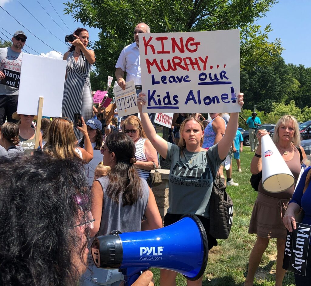 Protesters descend on Murphy's mask event.